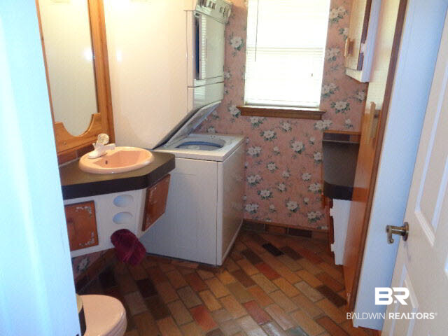 28202 Vargo Lane Elberta, AL 36530 - Photo 15 of 45 Brick floor. Vanity. Custom mirrors. Built-in ironing board. Kenmore heavy duty stack washer/ gas dryer.