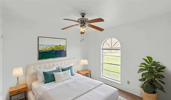 an empty room with windows and fan