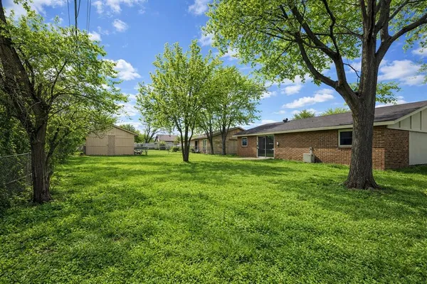 a view of a backyard with a garden and entertaining space