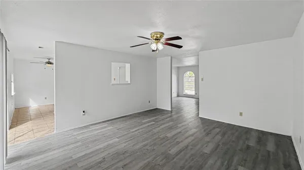 a view of a room with wooden floor and a ceiling fan