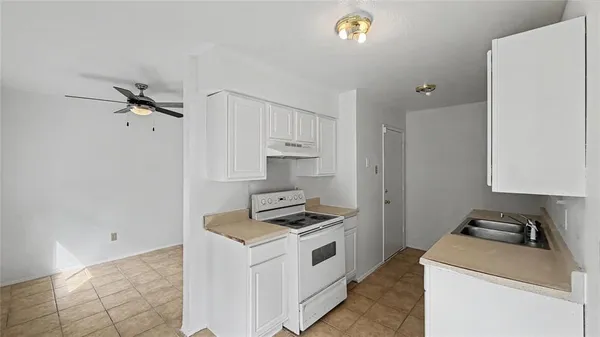 a kitchen with a sink stove and cabinets