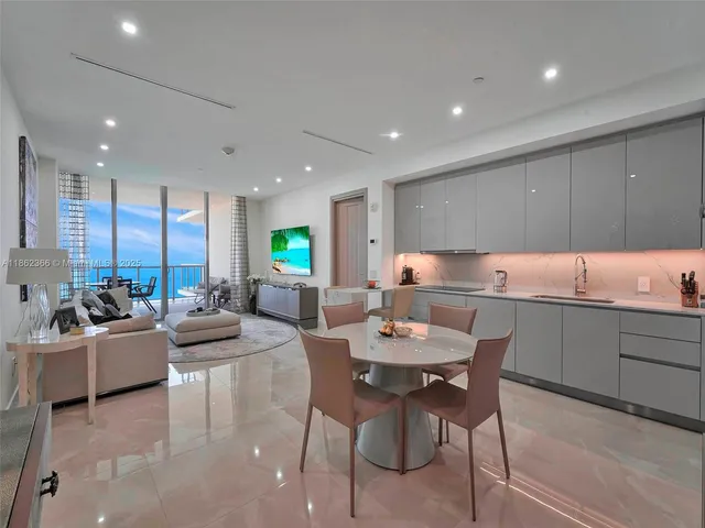 a kitchen with a dining table chairs and view living room