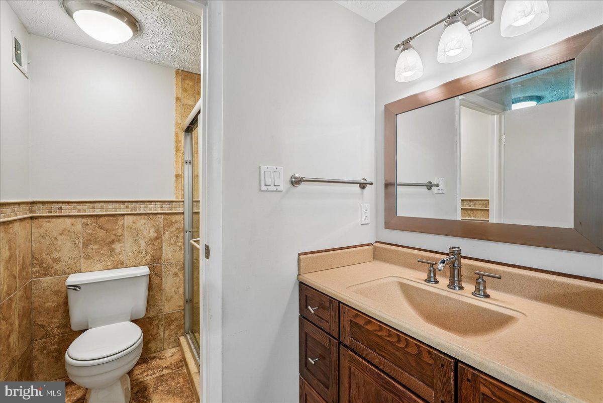 2331 Middle Creek Lane Reston, VA 20191 - Photo 30 of 78 a bathroom with a granite countertop sink mirror vanity and toilet