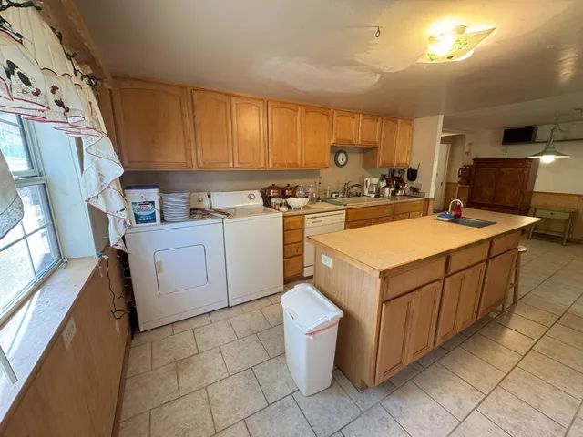 a living room with furniture a refrigerator and a flat screen tv