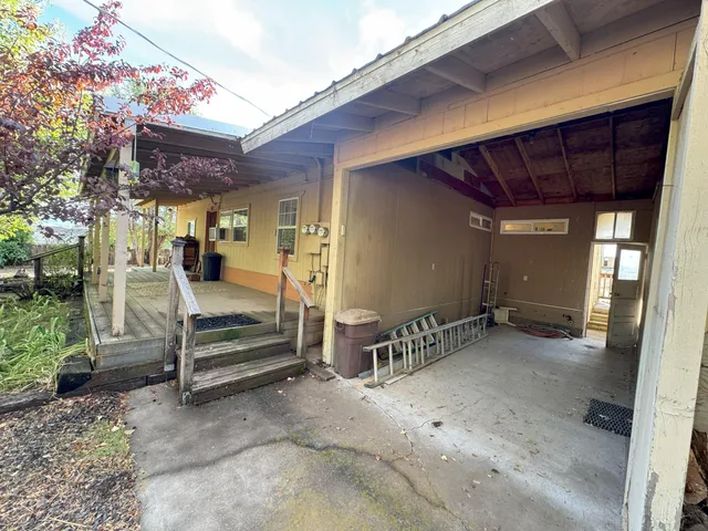 a view of backyard with wooden deck and outdoor seating