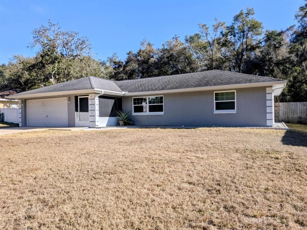 a front view of house with yard and trees in the background