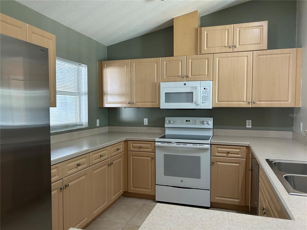 3764 East Sanders Street Inverness, FL 34453 - Photo 18 of 39 a kitchen with white cabinets and white appliances