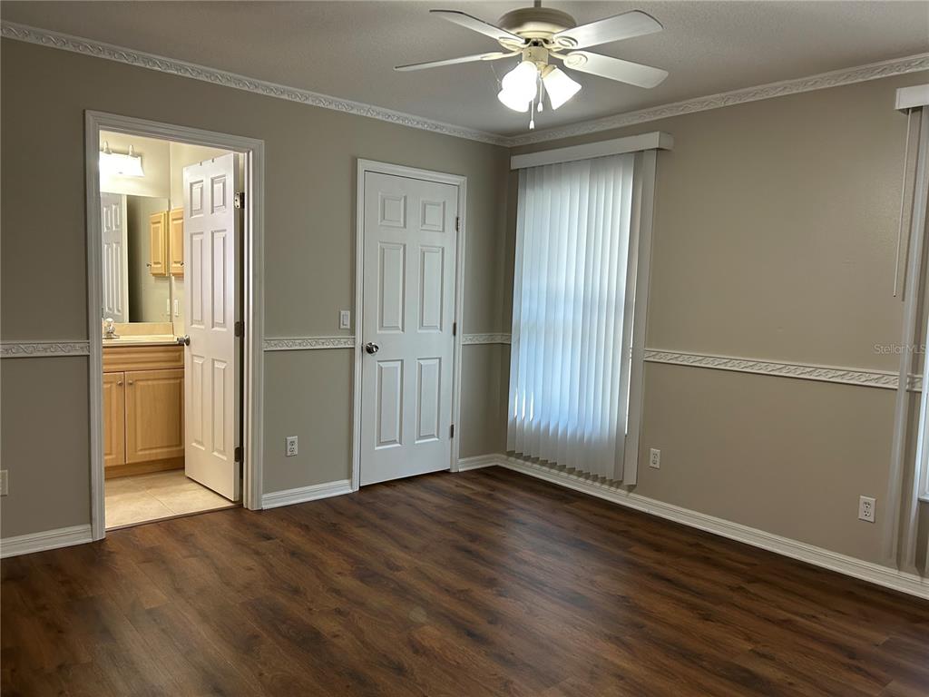 3764 East Sanders Street Inverness, FL 34453 - Photo 20 of 39 an empty room with wooden floor closet fan and windows