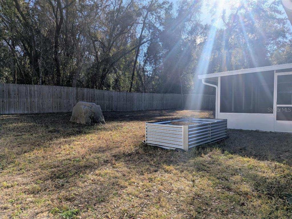 3764 East Sanders Street Inverness, FL 34453 - Photo 34 of 39 a view of a backyard with a small cabin and wooden fence