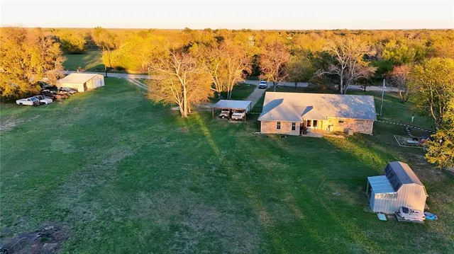a aerial view of a house with swimming pool and large trees