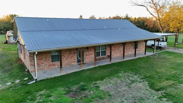a backyard of a house with table and chairs