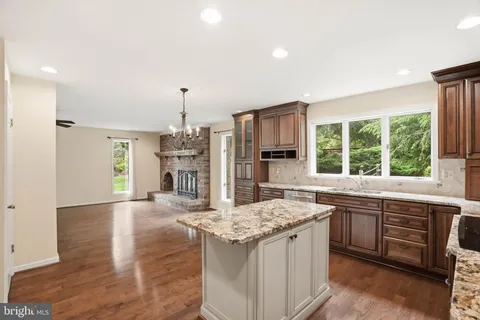 a kitchen with kitchen island granite countertop a sink stove and refrigerator