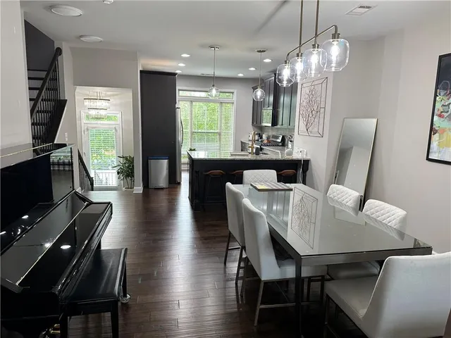 a view of a dining room with furniture a chandelier and wooden floor
