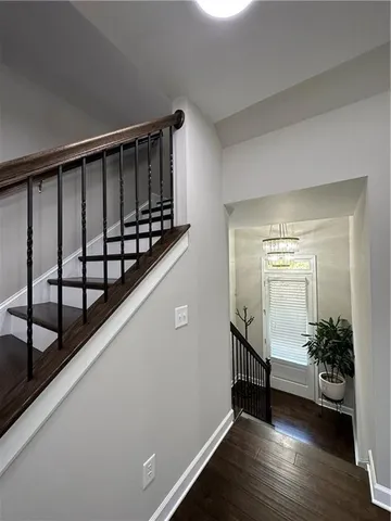 a view of a hallway with wooden floor and stairs