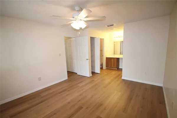 a view of a livingroom with a chandelier fan and wooden floor