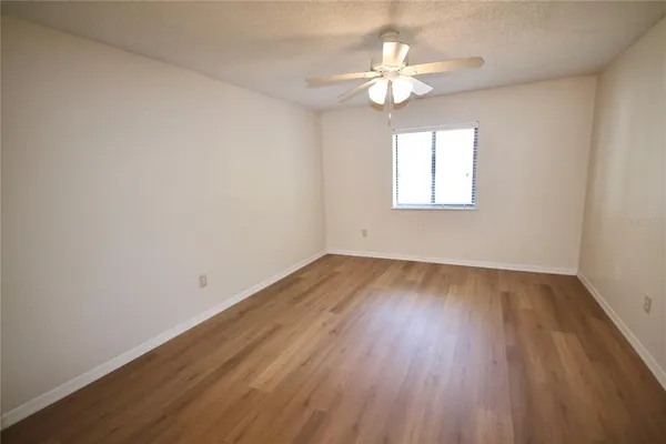 a view of a hallway with wooden floor and closet space