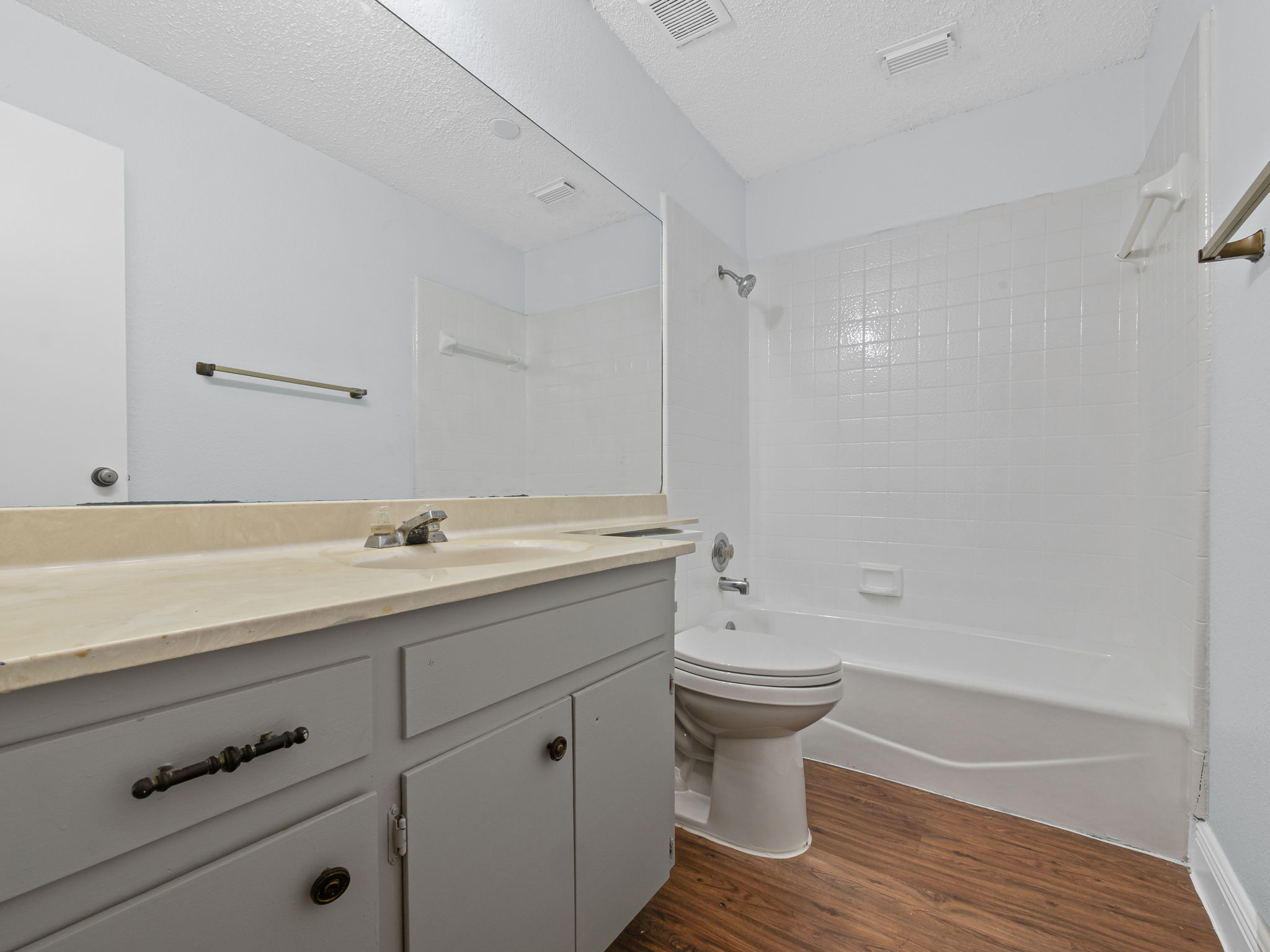 1816 Rawhide Loop, Unit 1822 Round Rock, TX 78681 - Photo 16 of 17 Bathroom featuring wood finished floors, shower / tub combination, vanity, and a textured ceiling