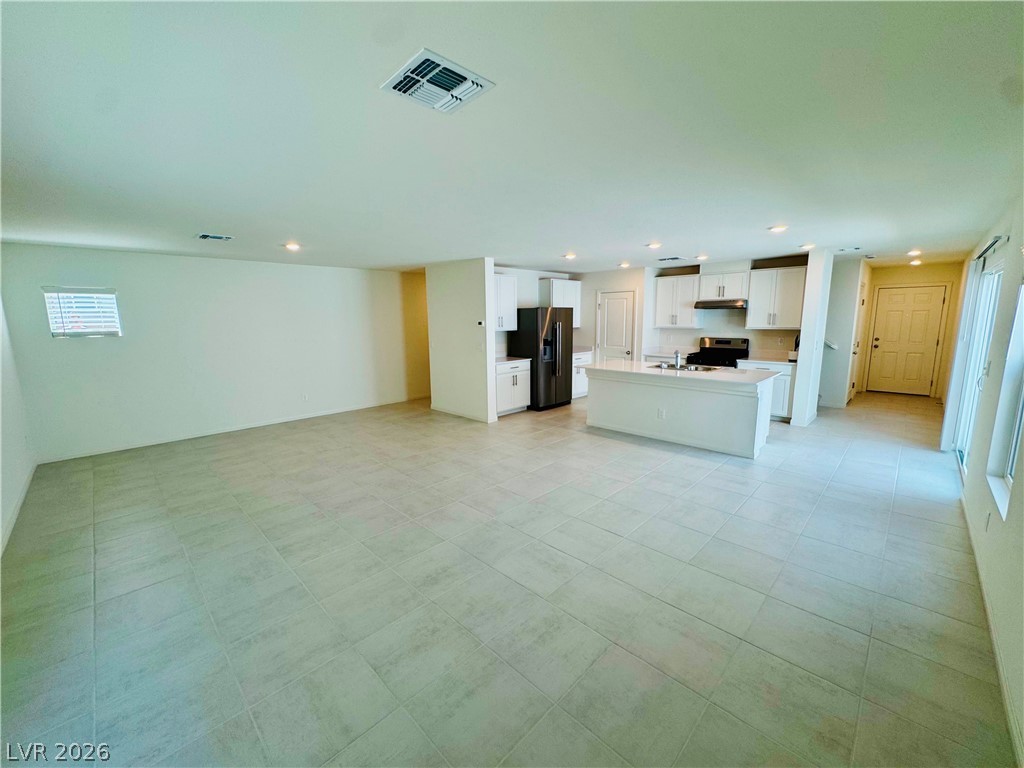 9249 Innot Avenue Las Vegas, NV 89148 - Photo 24 of 24 An open floorplan seamlessly connects a sleek kitchen to a spacious living area.