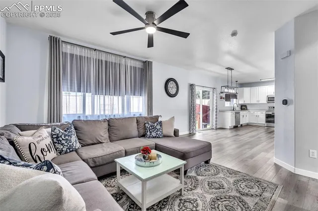 a living room with furniture and a wooden floor