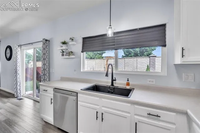 a kitchen with stainless steel appliances a sink a window and wooden floor
