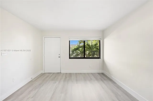 a view of a room that has wooden floor and window