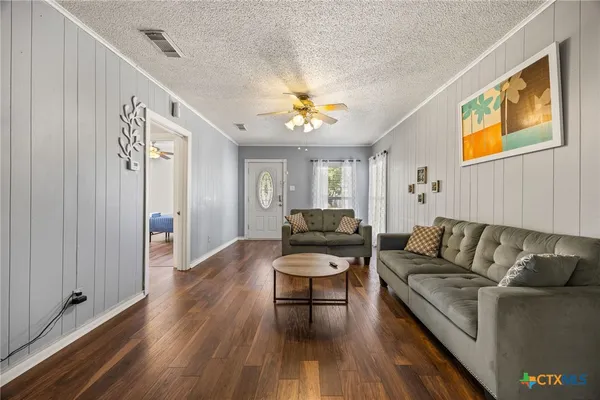 a living room with furniture and a wooden floor