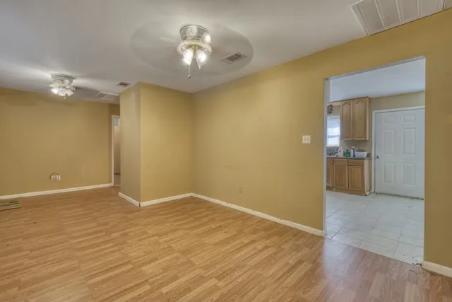 a view of empty room with wooden floor