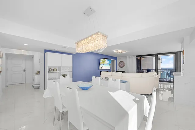 a large white kitchen with stainless steel appliances granite countertop a sink and dishwasher a oven with white cabinets