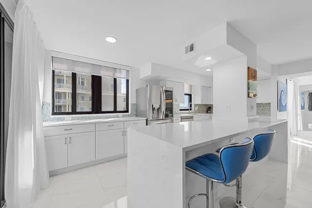 a kitchen with white cabinets sink and white appliances