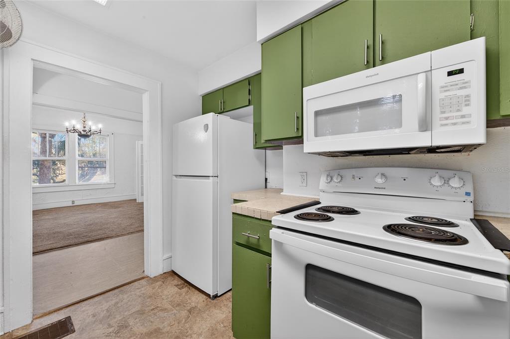 1616 Cres Ridge Road Daytona Beach, FL 32118 - Photo 15 of 40 a kitchen with white cabinets and white appliances