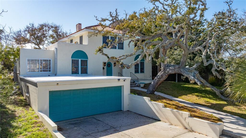 1616 Cres Ridge Road Daytona Beach, FL 32118 - Photo 3 of 40 a view of a white house with a large tree and a yard