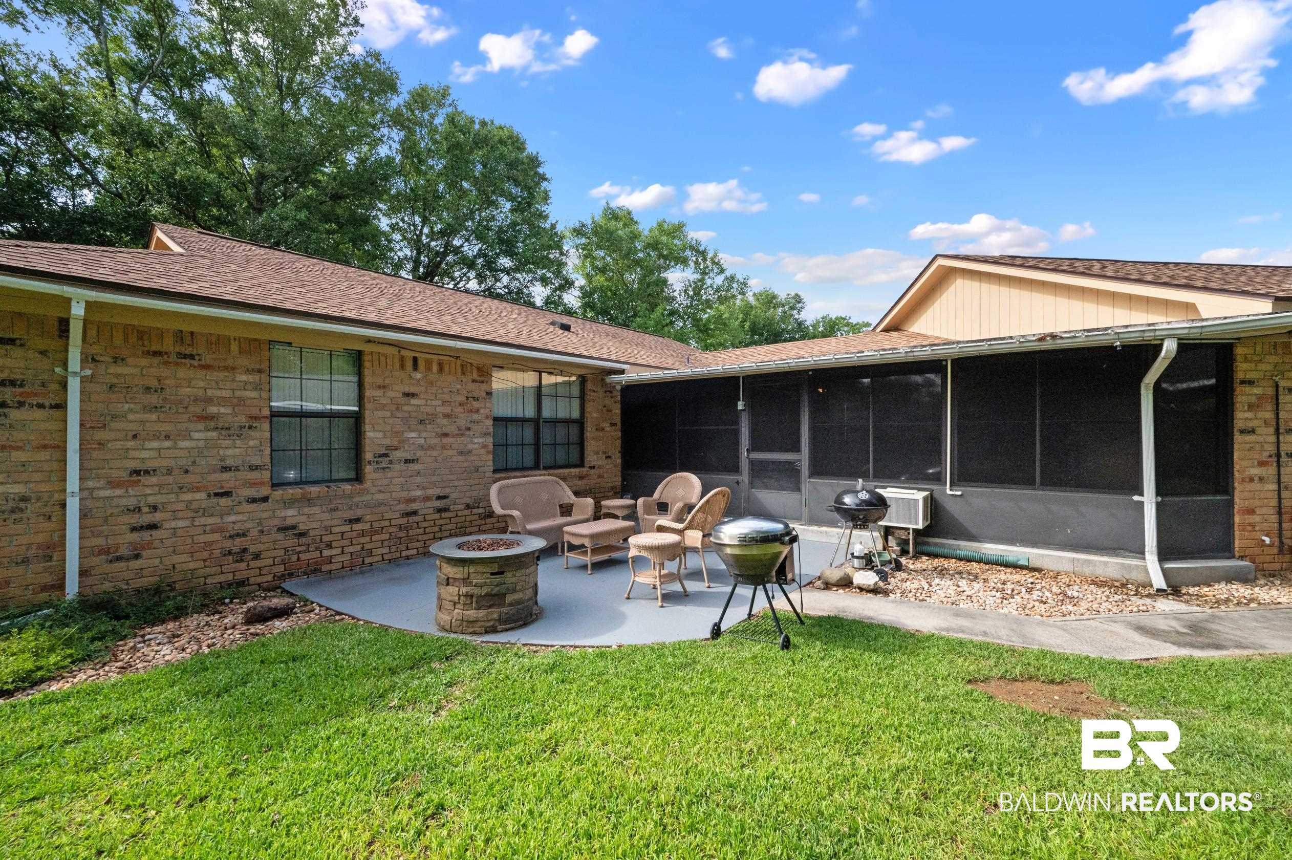 2772 Santa Rosa Circle Lillian, AL 36549 - Photo 30 of 50 Back of house featuring a patio, a sunroom, a yard, and an outdoor fire pit