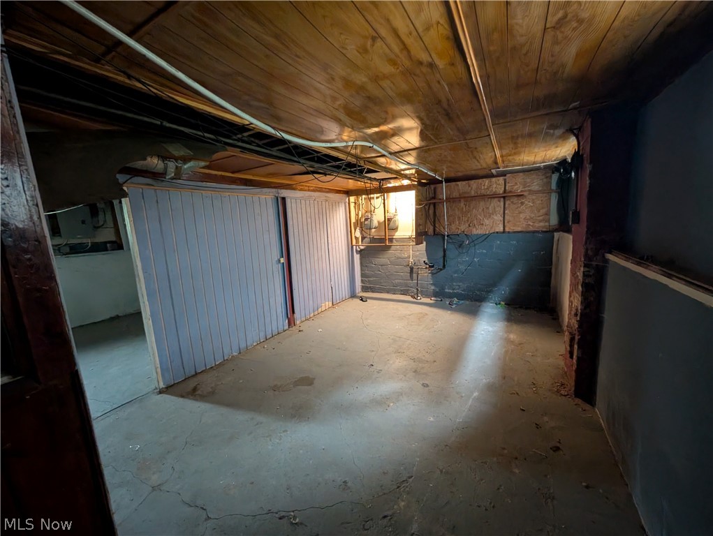 475 East 146th Street Cleveland, OH 44110 - Photo 24 of 28 Basement storage area featuring concrete flooring, wood panel ceiling, and built-in wood shelving