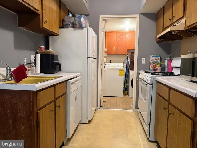 a kitchen with a refrigerator a stove top oven a sink and dishwasher