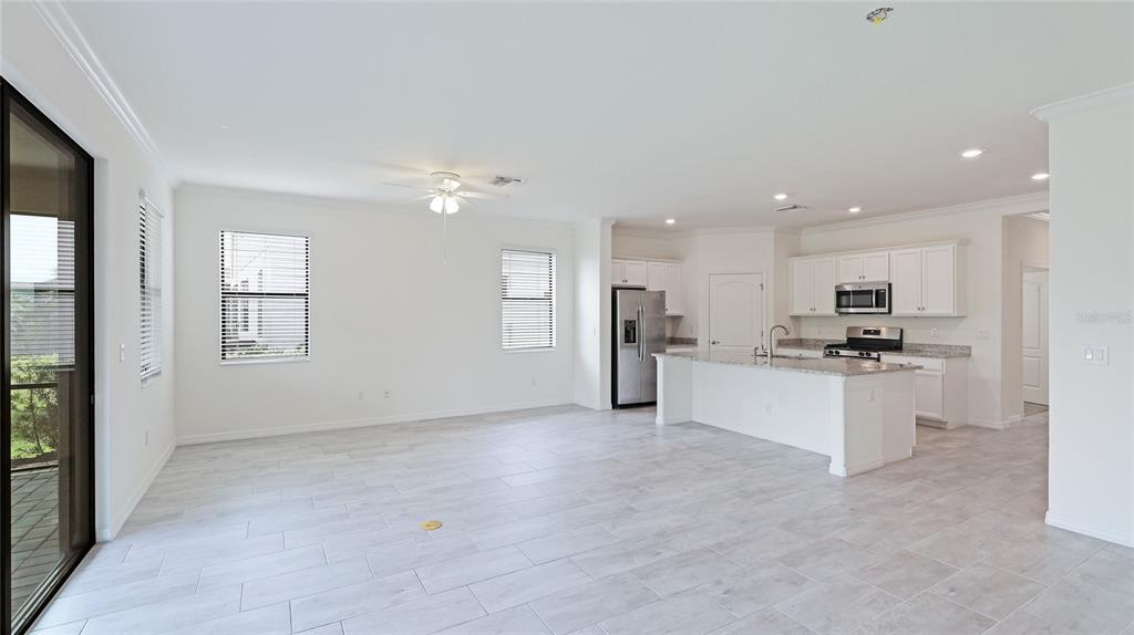 17311 Blue Ridge Place Bradenton, FL 34211 - Photo 12 of 55 a kitchen with stainless steel appliances kitchen island granite countertop a stove top oven a sink and a refrigerator