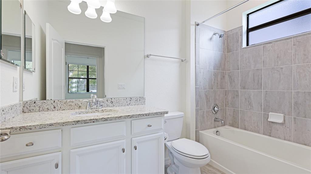 17311 Blue Ridge Place Bradenton, FL 34211 - Photo 30 of 55 a bathroom with a granite countertop sink a toilet and bathtub