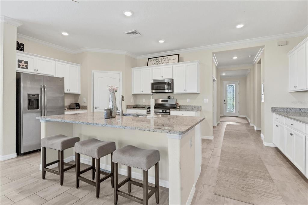 17311 Blue Ridge Place Bradenton, FL 34211 - Photo 6 of 55 a kitchen with kitchen island granite countertop a sink and cabinets