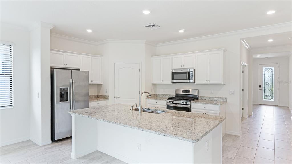 17311 Blue Ridge Place Bradenton, FL 34211 - Photo 7 of 55 a kitchen with stainless steel appliances granite countertop a stove refrigerator and microwave