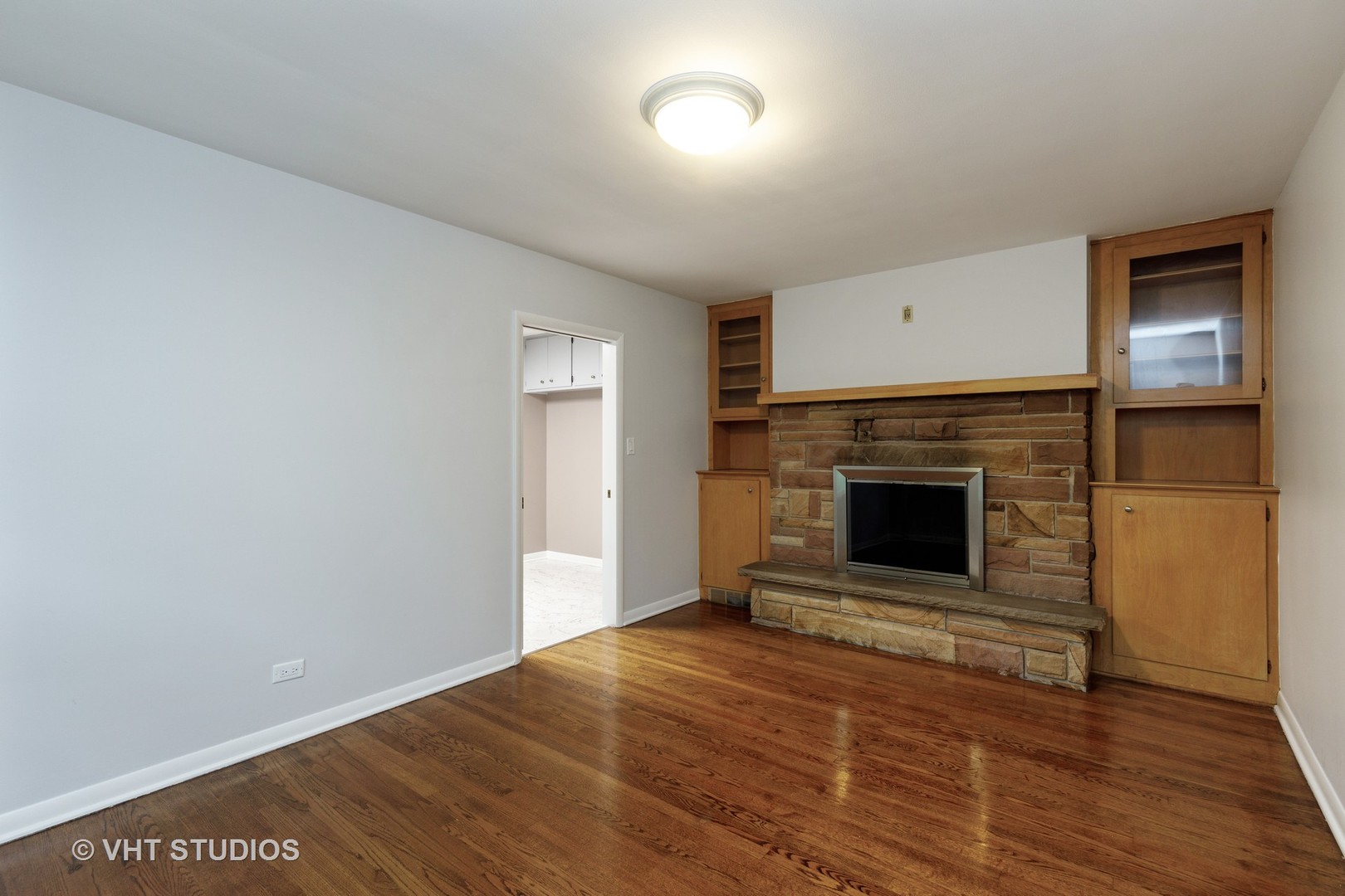 175 Barrypoint Road Riverside, IL 60546 - Photo 8 of 21 a view of empty room with wooden floor and a fireplace