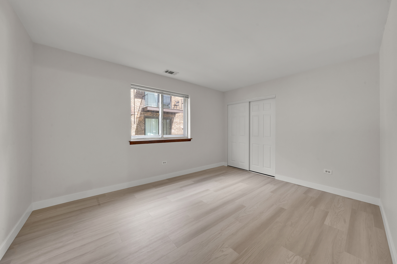 9615 Bianco Terrace, Unit 1A Des Plaines, IL 60016 - Photo 11 of 16 an empty room with wooden floor and windows