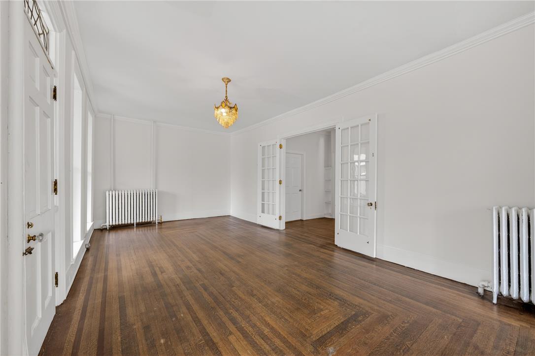 65 2nd Street Slatington, PA 18080 - Photo 9 of 46 This living area features rich hardwood flooring, a statement chandelier, and elegant french doors, creating a refined atmosphere.