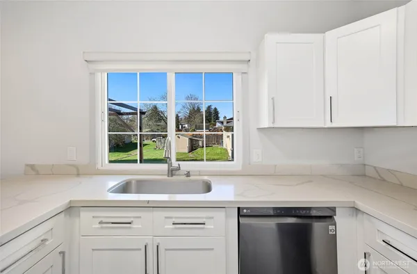 a kitchen with stainless steel appliances white cabinets and a window
