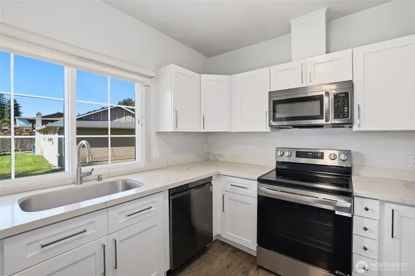a kitchen with cabinets stainless steel appliances and a sink