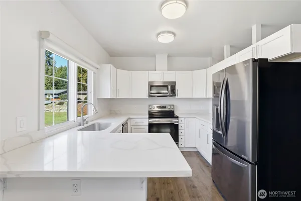 a kitchen with stainless steel appliances a refrigerator sink and microwave
