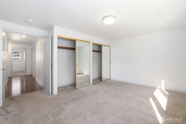 an empty room with closet and a chandelier fan