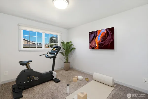 a living room with furniture a flat screen tv and a potted plant