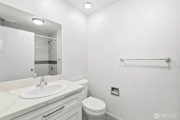 a bathroom with a sink a toilet and a mirror
