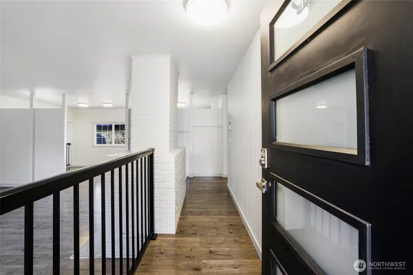 a view of a hallway with wooden floor and staircase