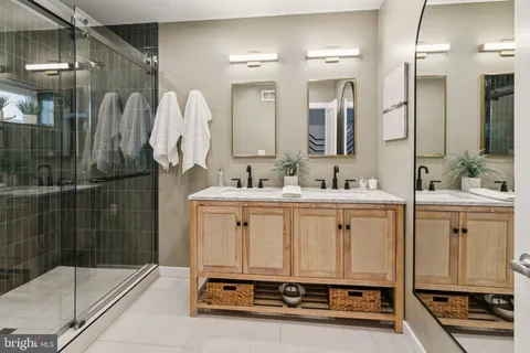a bathroom with a double vanity sink mirror and shower