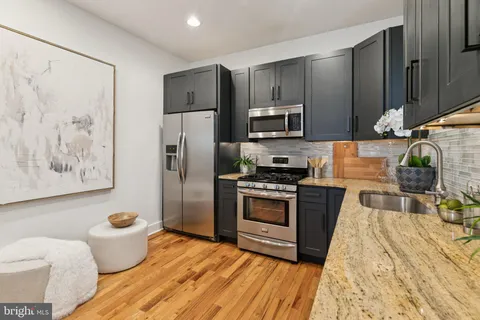 a kitchen with stainless steel appliances a refrigerator sink and stove